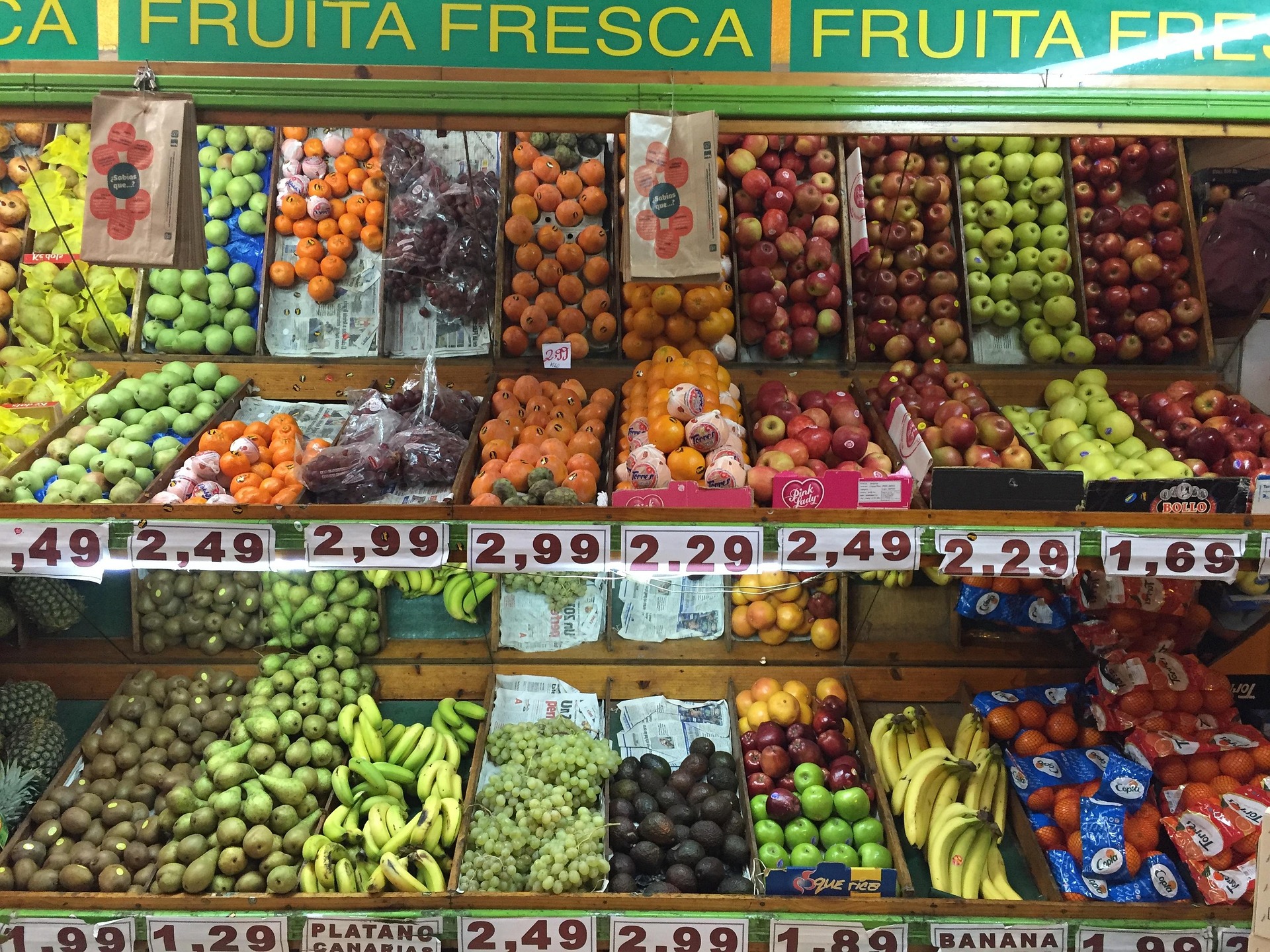 A bustling market stall in Barcelona overflowing with colorful fresh fruits and vegetables