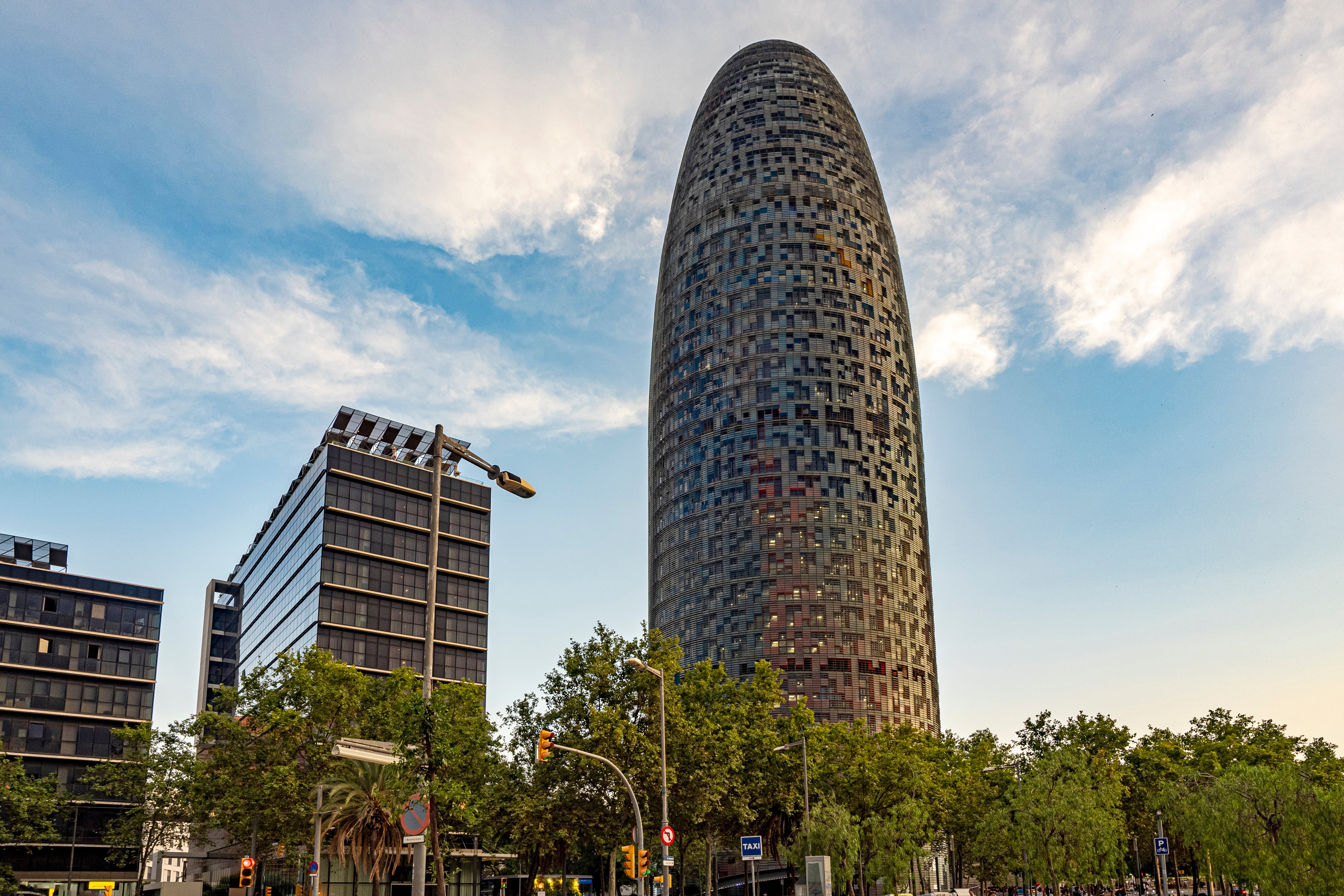 Modern buildings and green spaces in Poblenou, Barcelona, with the sea in the background.