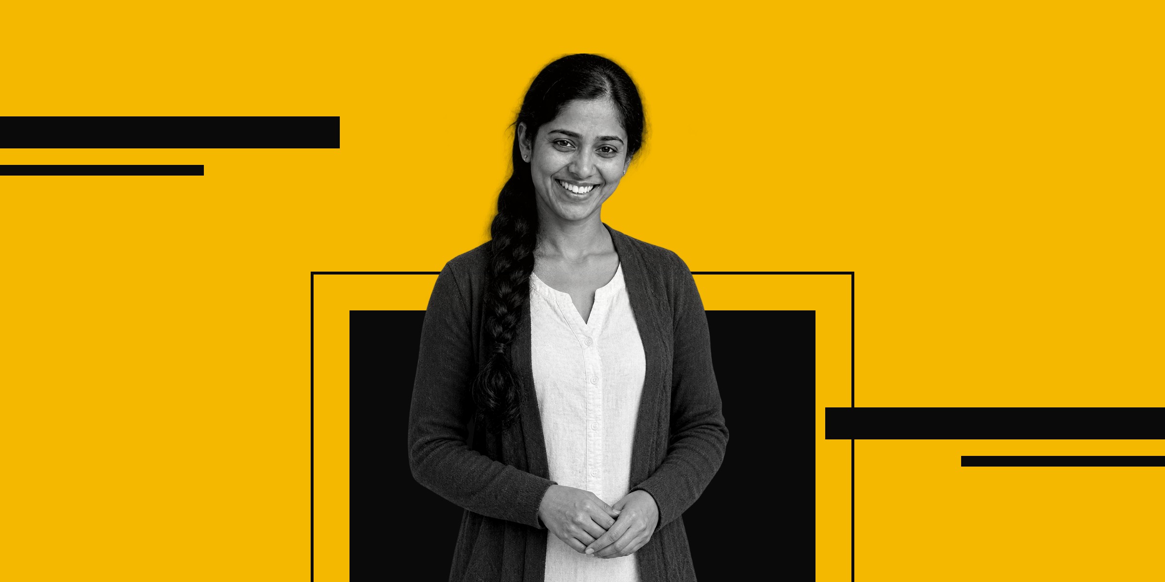 A smiling woman in a teal cardigan standing in front of a black box on a yellow background